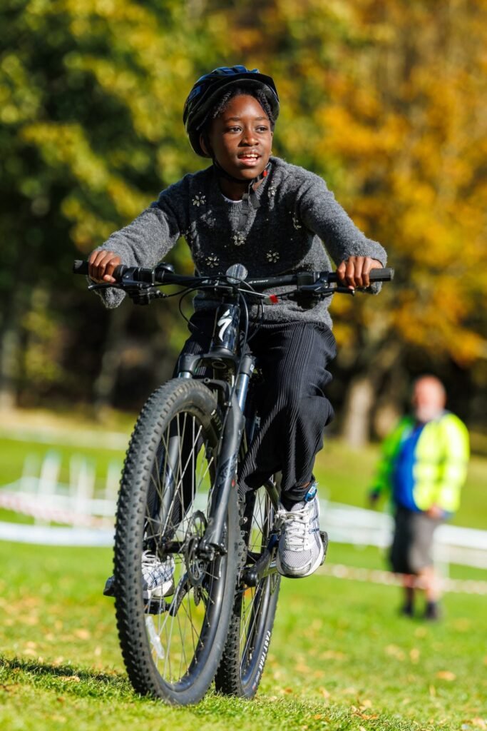 Young rider in a grey jumper riding towards the camera