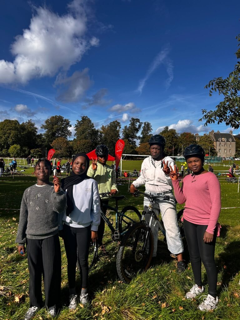 Livity riders smiling with a bike at the Inch Park Cyclocross
