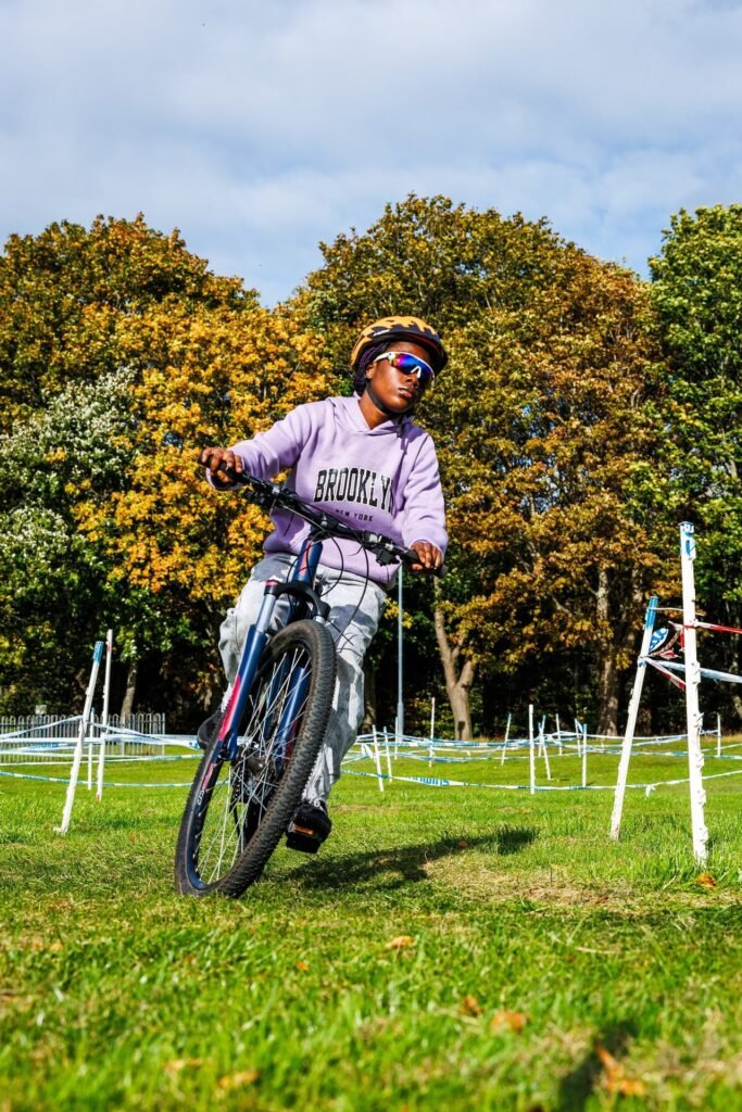 Young rider in a lilac top cornering on the cyclocross course