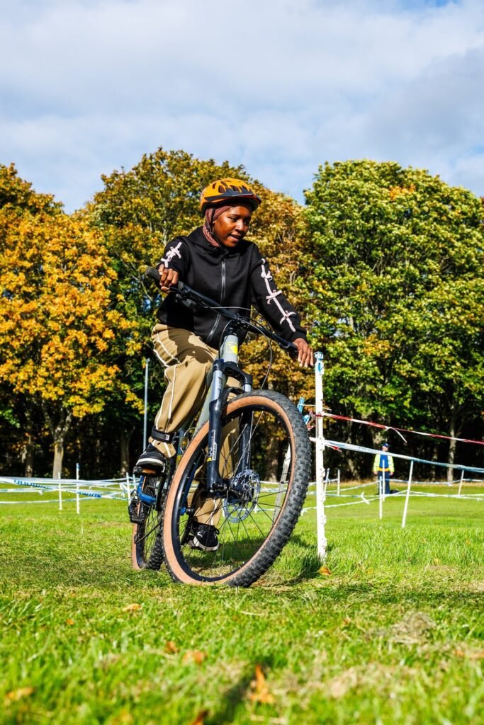 Young rider in a black jacket steering through the course markers